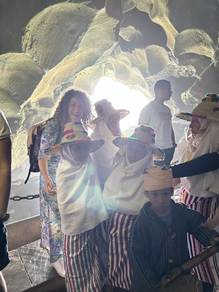 Niños en la apertura natural de las Cuevas de Hércules con la silueta del mapa de África invertido
